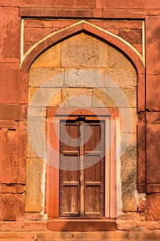 A architecture of gate at humayun tomb memorial from the side of the lawn at winter foggy morning