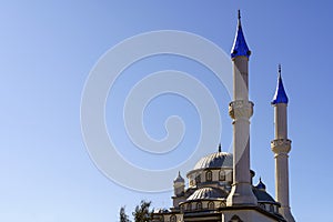 Architecture of the Islamic mosque in Turkey against the sunny blue sky background. Byzantine style Muslim mosque.