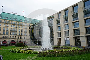 Historic fountain on Pariser Platz surrounded by flower beds in the center of Berlin near Brandenburg Gate. Berlin, Germany.