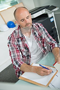 Architecture man writing paper at table office