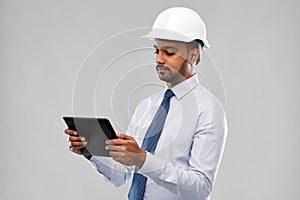 Architect or businessman in helmet with tablet pc