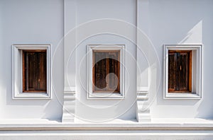 Architecture of Thailand's public temple's wall with three wooden windows