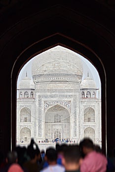 Archway of main gateway in Taj Mahal entrance with tourists silhouettes, view to Taj Mahal mausoleum