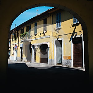 Archway to a street with traditional shops in Italy