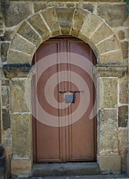 Arco en piedra con puerta en madera.