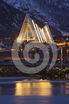 The arctic cathedral in Tromso reflected in the fjord.