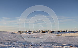 Arctic community of Cambridge Bay in the fall with snow on the ground and blue skies