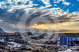 Arctic houses growing on the rocky hills in sunset panorama. Nuuk, Greenland