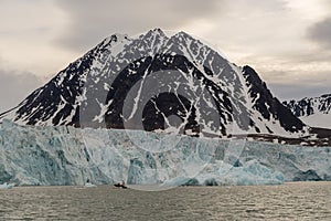 Arctic landscape people in the zodiac approach the glacier descending to the Gulf