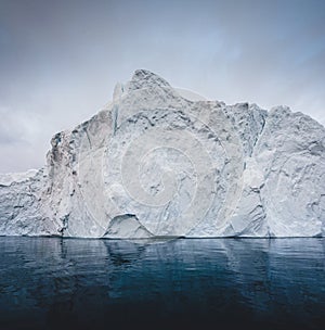 Arctic nature landscape with icebergs in Greenland icefjord with midnight sun sunset sunrise in the horizon. Early