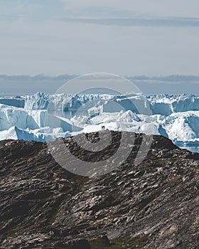 Arctic nature landscape with icebergs in Greenland icefjord with midnight sun sunset sunrise in the horizon. Early