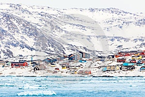 Arctic snow city panorama with colorful Inuit houses on the rock