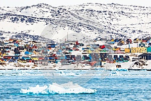 Arctic snow city panorama with colorful Inuit houses on the rock