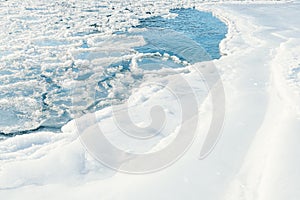 Arctic winter landscape in frozen bay. Floating ice floes in river on white frost bank