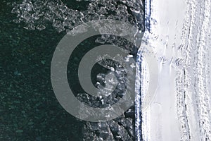 Arctic winter landscape in frozen bay. Floating ice floes in river on white frost bank