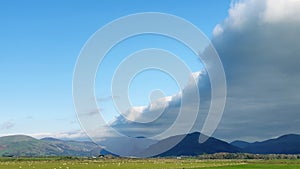 Arcus cloud formation in the form of shelf or rolling clouds over rural mountain landscape