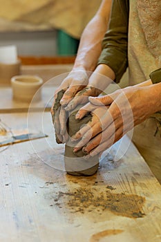 Ardent young couple having romantic masterclass in pottery workshop