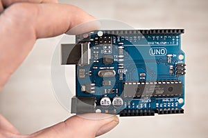Arduino Uno board electronics in hand for programming the microcontroller