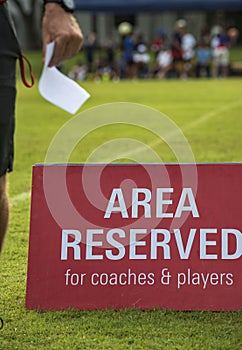 Area reserved banner sign on the sideline of a football pitch in a youth tournamen.