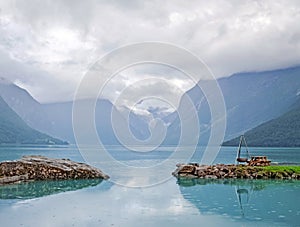 Area for rest or picnic with table and grill in the scenic place near mountain lake