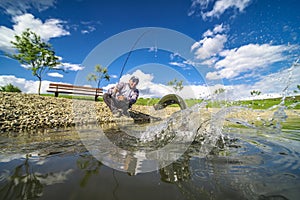 Area trout fishing. Fish jump splash. Fisherman cath fish on lake by spinning rod