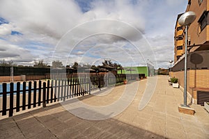 Area of an urbanization of communal summer pools with gardens, tarpaulins to spend the winter, a black wooden fence and straw