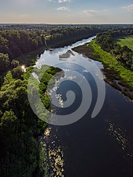 Areal countryside view o river Venta flowing through lovely environment with trees on a warm summer day