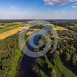 Areal countryside view o river Venta flowing through lovely environment with trees on a warm summer day