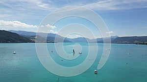 Areal footage of a Pier with boats in a clear transparent water in Attersee, Austria