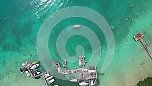 Areal footage of a pier with boats in clear transparent water in Attersee, Austria