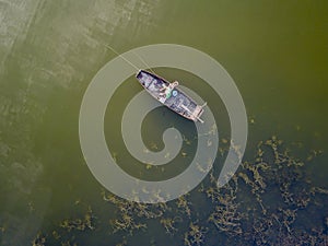 Areal view on angling fisherman in boat on lake