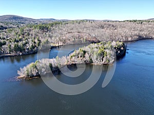 Areal view of a tranquil lake in New Hampshire, surrounded by lush green trees set in a wooded area