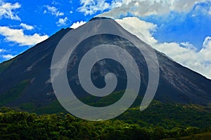 Arenal Volcano in Costa Rica. Volcano with exhalation and ash. Beautiful tropic landscape with volcano. Cone active volcano in photo