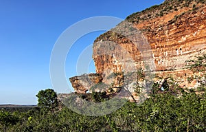 Arenite rock, in Jalapao, Brazil, contrasting with the blue sky and green fields.