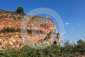 Arenite rock, in Jalapao, Brazil, contrasting with the blue sky and green fields.