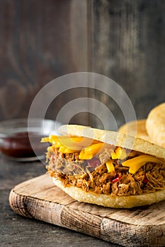 Arepa with shredded beef and cheese on wood. Venezuelan typical food photo