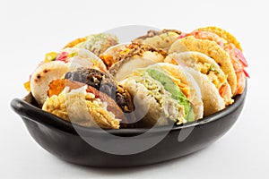 Arepas with assorted fillings served in a black ceramic dish photo