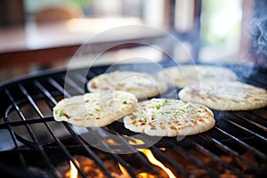 arepas cooking on a flame with grill marks