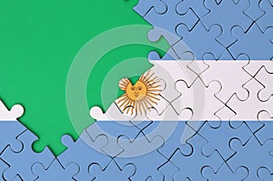 Argentina flag is depicted on a completed jigsaw puzzle with free green copy space on the left side