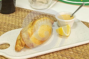 Argentine empanada with dip sauce accompanied by lemon