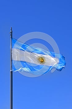 Argentine Flag. Flag of Argentina waving in blue sky. on sunny day. Blue and white striped flag with sun in the middle. photo