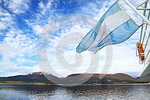 Argentine flag of a cruise ship waving in the sunlight, Beagle channel, Ushuaia, Argentina