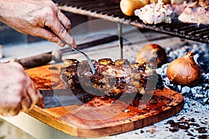 Argentine man cutting roast beef ribs. Asado from Argentina. Barbecue photo