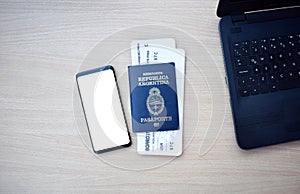 Argentine passport and boarding pass with smartphone with copy space on wooden table photo