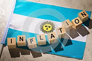Argentinean flag and wooden cubes with text on an abstract background, concept on the topic of inflation in Argentina