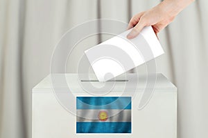 Argentinean Vote concept. Voter hand holding ballot paper for election vote on polling station photo