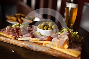 Charcuterie board with salami, pepperoni, ham, olives, cheese and vegetables photo