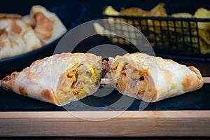 Argentinian chicken empanada, visible filling, potato wedges and premium cutlery