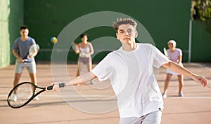 Argentinian guy playing frontenis at open-air fronton court in summer