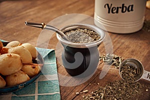 Mate tea cup and yerba mate dried leaves whit cheese bread called chipa photo